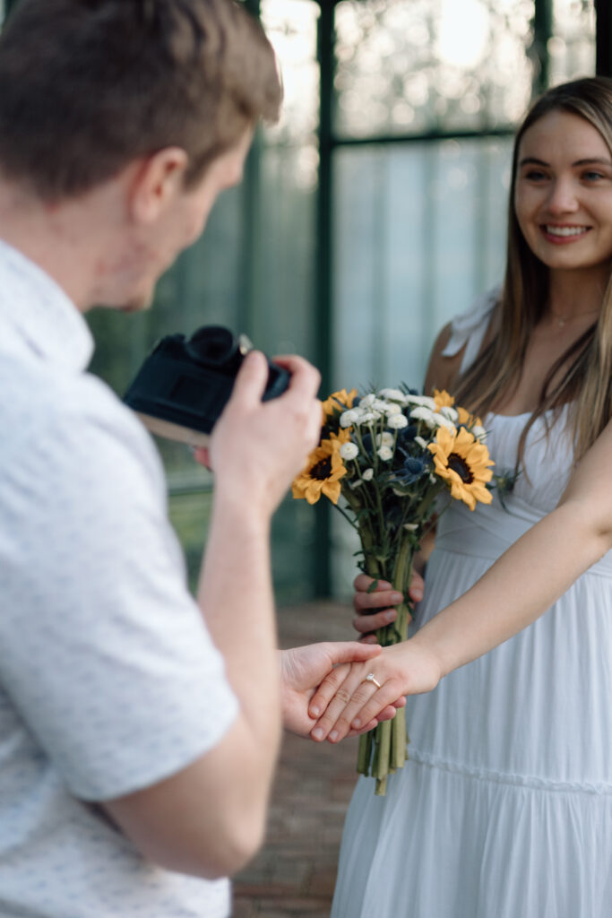 Engaged couple taking photos of each other during their engagement session.