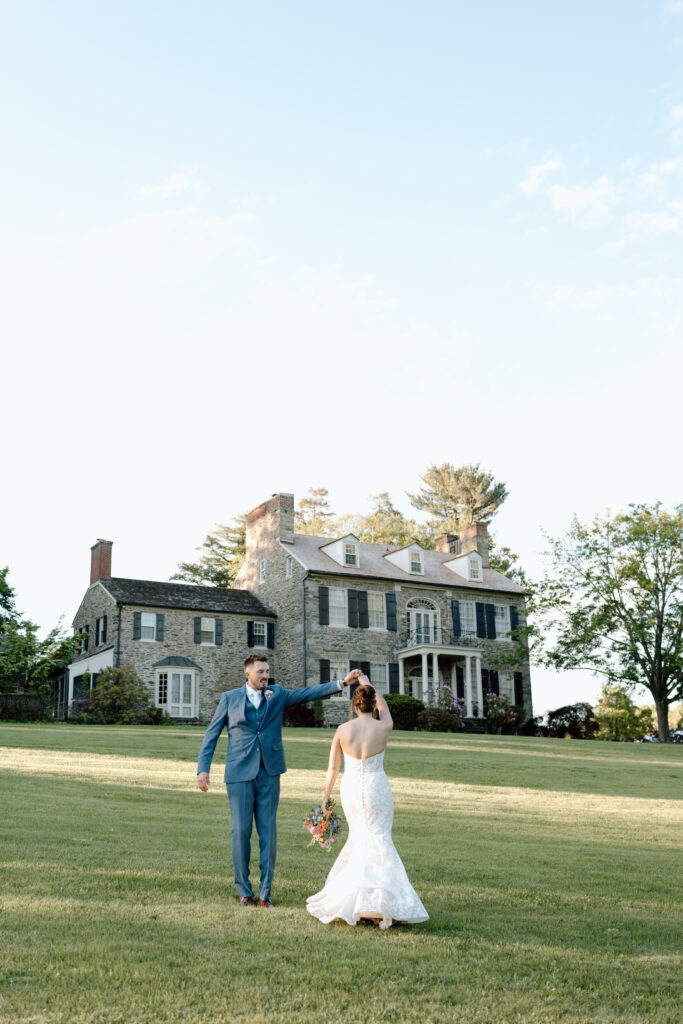 Groom spinning his wife outside their wedding venue.