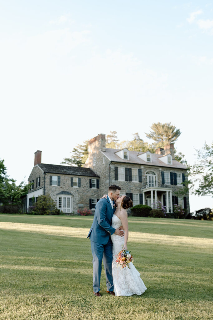 Newlyweds kissing in front of their wedding venue. 