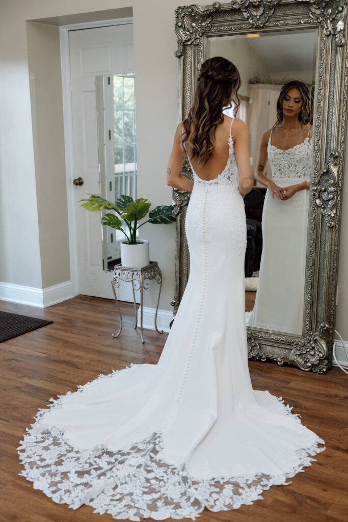 Bride admiring her dress in the mirror.