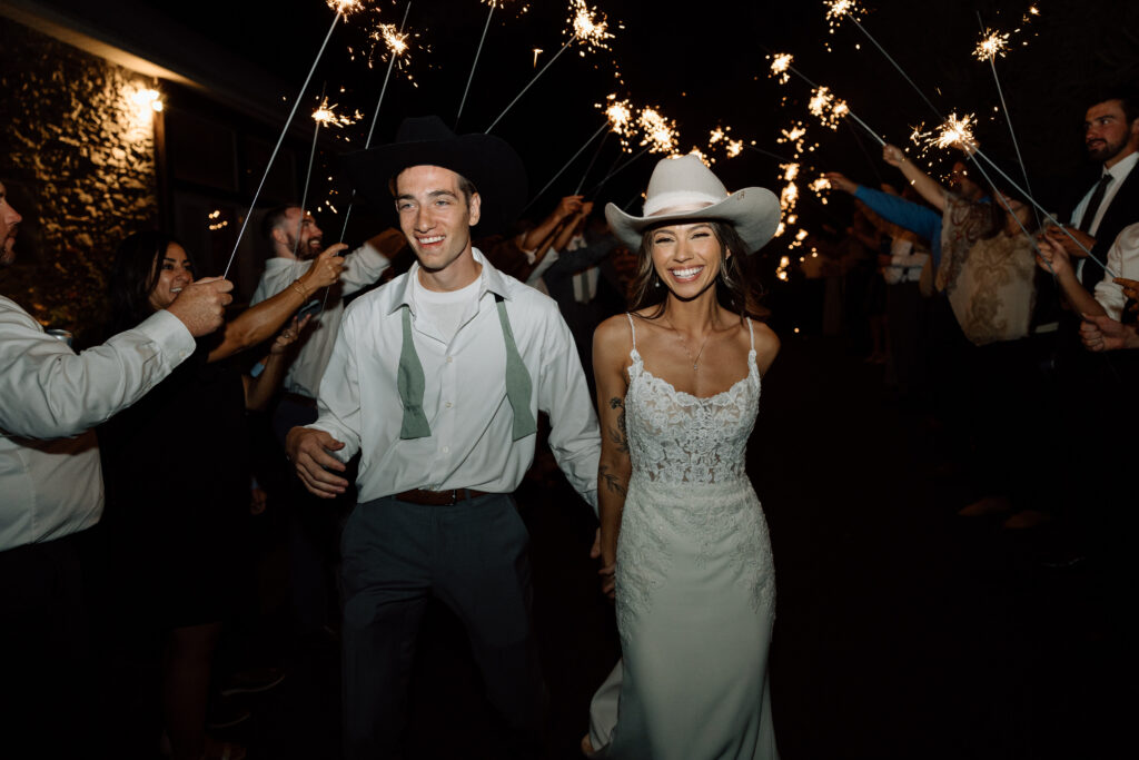Bride and groom during their sparkler exit showing how to pick a wedding photographer.