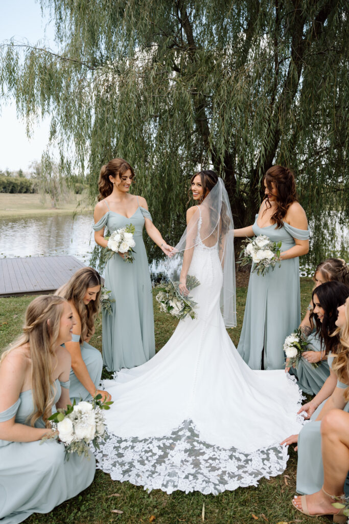 Bridal party helping the bride fix her dress and hair.