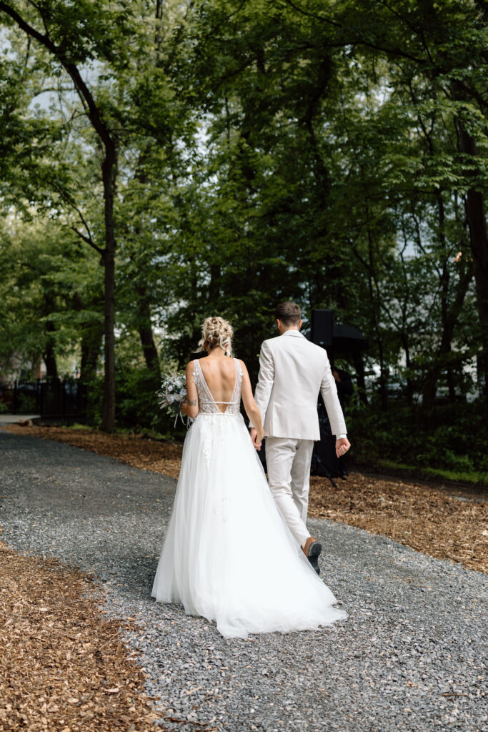 Bride and groom walking away from their ceremony while holding hands. 