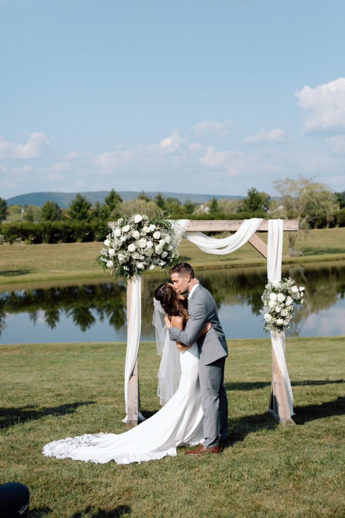 Bride and groom kissing at the altar at Wind in the WIllows.