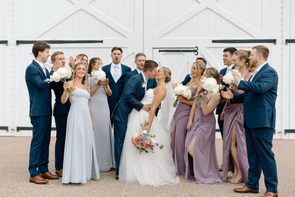 Bride and groom while the wedding party cheers outside the Star Barn in Pennsylvania. 