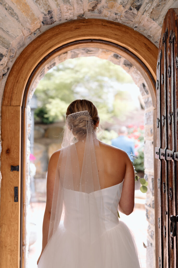 Bride walking through an arched doorway at The Star Barn in PA, one of the best Pennsylvania wedding venues.