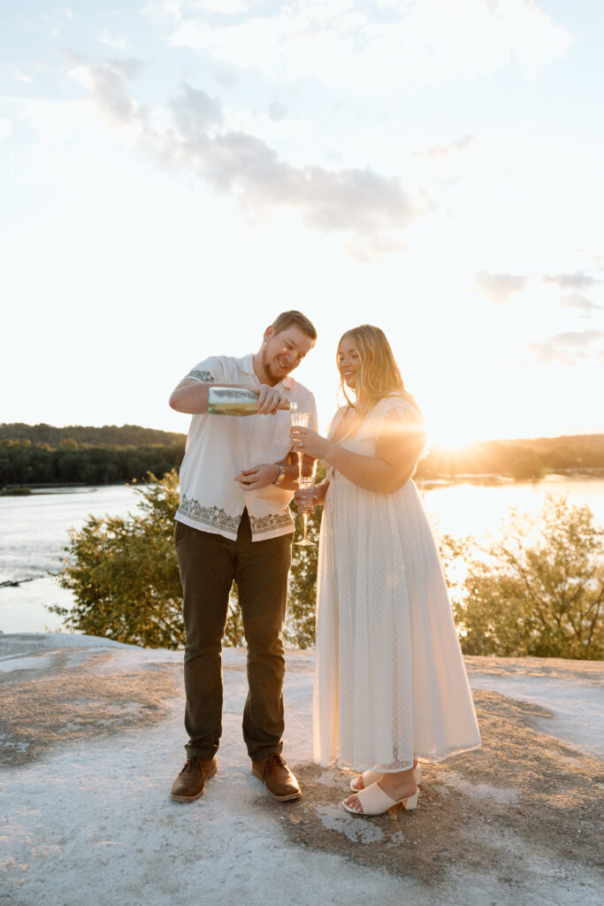 Engaged couple pouring champagne at the White Cliffs of Conoy. 