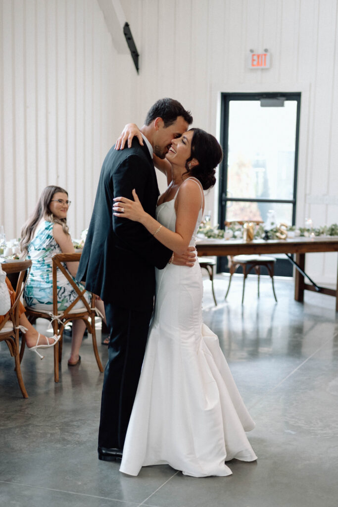 Documentary style wedding photography of a bride and groom sharing their first dance.