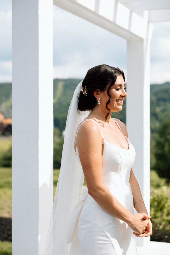 Bride smiling at the groom during his vows.