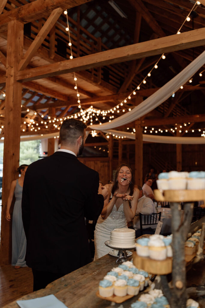 Bride with cake icing on her face laughing.