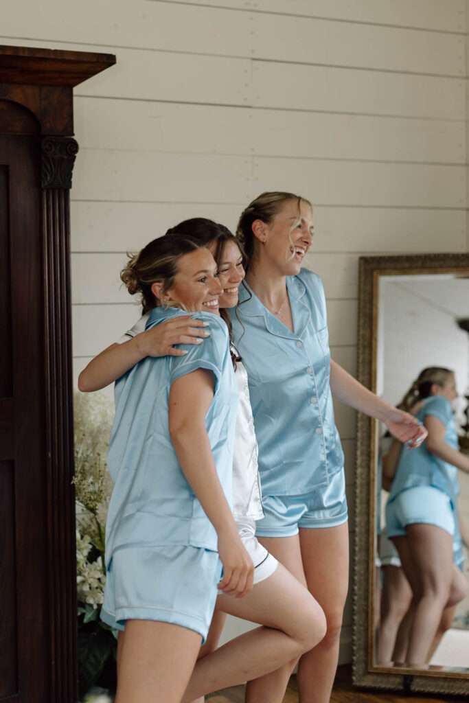 Bride and her bridesmaids hugging for a photo.