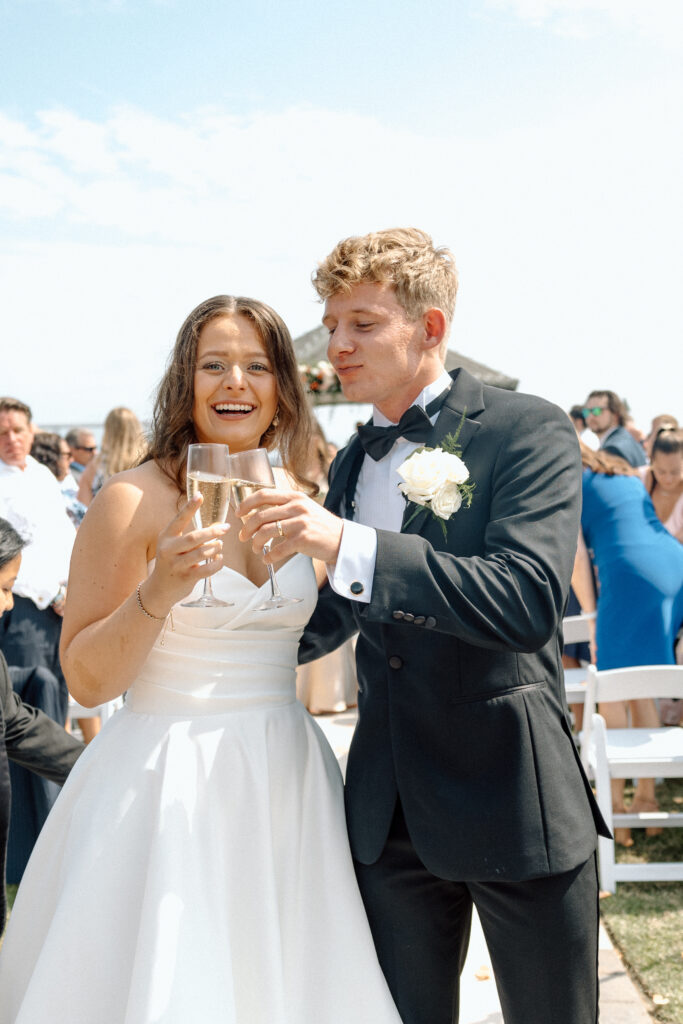Documentary style wedding photography of bride and groom drinking champagne after their luxury wedding ceremony. 